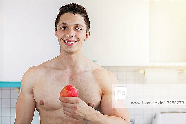 Healthy diet young bodybuilder man text free space food apple fruit fruit in the kitchen copyspace in germany