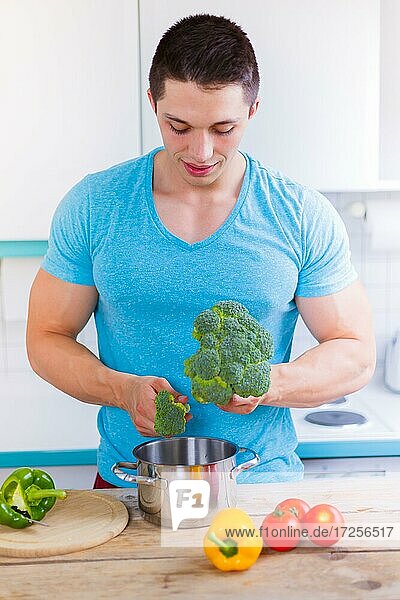 Young man cooking food vegetables lunch in kitchen healthy food vertical in germany