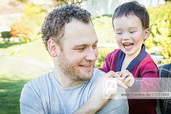 Happy caucasian father having fun with his mixed race baby son