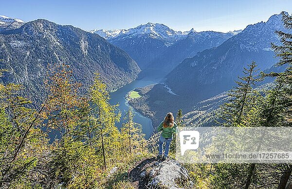 Panoramablick auf den Königssee  Junge Wanderin auf der Achenkanzel  herbstlicher Wald und schneebedeckte Berge  Nationalpark Berchtesgaden  Berchtesgadener Land  Oberbayern  Bayern  Deutschland  Europa
