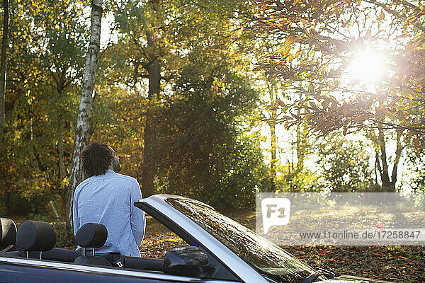 Mann am Cabrio im sonnigen Herbst Park