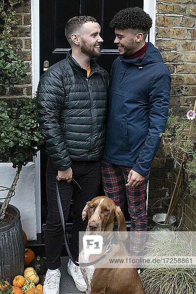 Glückliche Homosexuell männliches Paar mit Hund auf vorderen stoop
