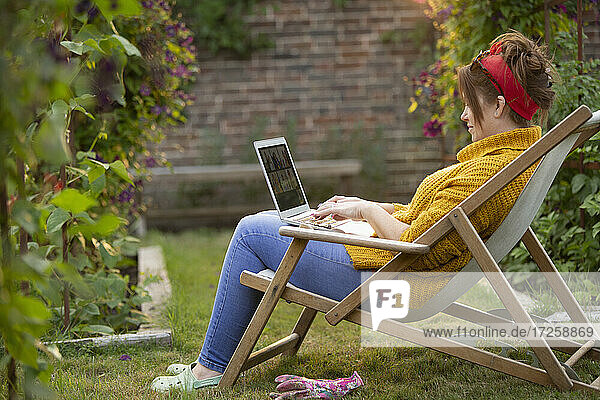 Frau arbeitet am Laptop im Garten