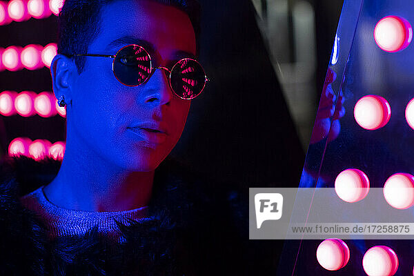 Close up Porträt kühlen jungen Mann mit Sonnenbrille in Neonbeleuchtung