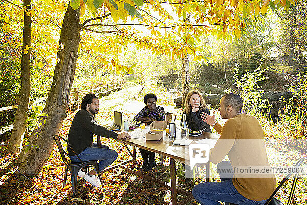 Geschäftsleute Essen und Treffen am Tisch in sonnigen Herbst Park