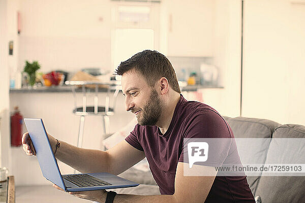 Man working from home at laptop on sofa