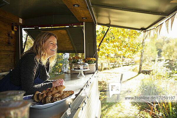 Glückliche weibliche Essen Wagen Besitzer in sonnigen Herbst Park