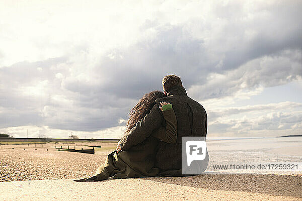 Serene zärtliches Paar umarmt auf sonnigen ruhigen Winter Strand