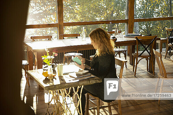 Geschäftsfrau arbeitet an sonnigen Café Tisch
