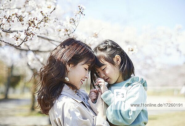 Japanisches Mädchen mit Mutter und Kirschblüten