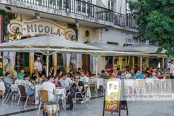 Historischer Eingang des Cafe Nicola mit Art-Deco-Fassade und sitzenden Kunden an Tischen im Freien am Rossio-Platz  Lissabon  Portugal  Europa