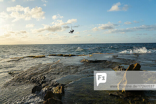 Ein Kiteboarder springt hoch über Felsen bei Montones  Puerto Rico  Karibik  Mittelamerika