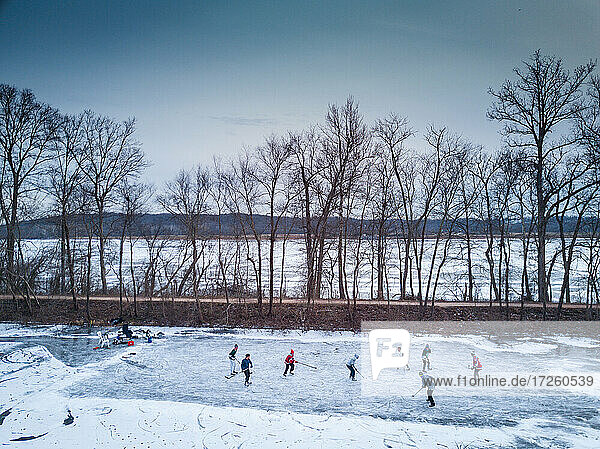 Ice skaters in a pond hockey game on the frozen C and O Canal (Chesapeake and Ohio Canal) next to the Potomac River  Maryland  United States of America  North America