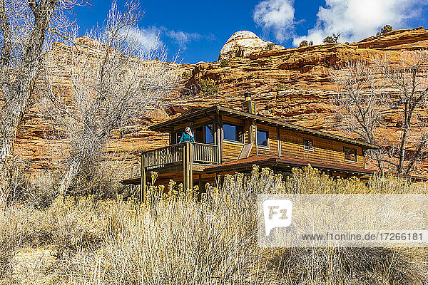 USA  Utah  Escalante  Woman on deck of home in canyon in Grand Staircase-Escalante National Monument