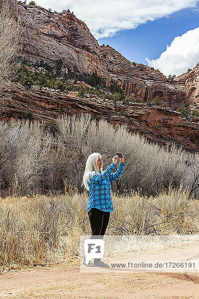 USA  Utah  Escalante  Woman taking pictures while hiking in Grand Staircase-Escalante National Monument