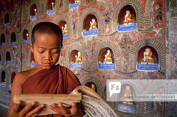 Myanmar  Shan State  Inle Lake  Novice Buddhist monk reading prayers in Shwe Yan Pyay Monastery