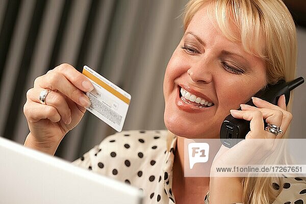 Schöne Frau am Telefon hält ihre Kreditkarte