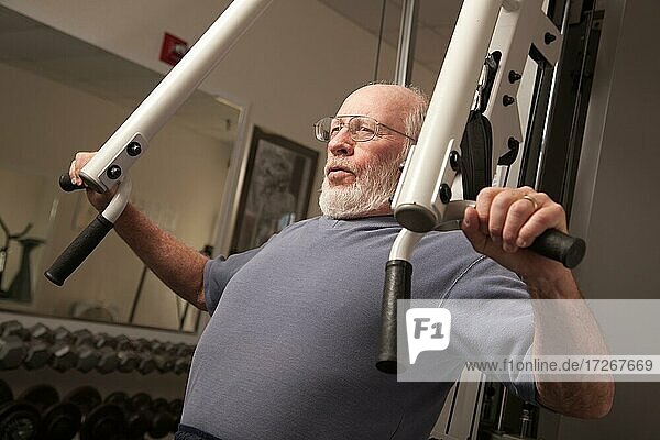 Aktiver älterer erwachsener Mann beim Training im Fitnessstudio