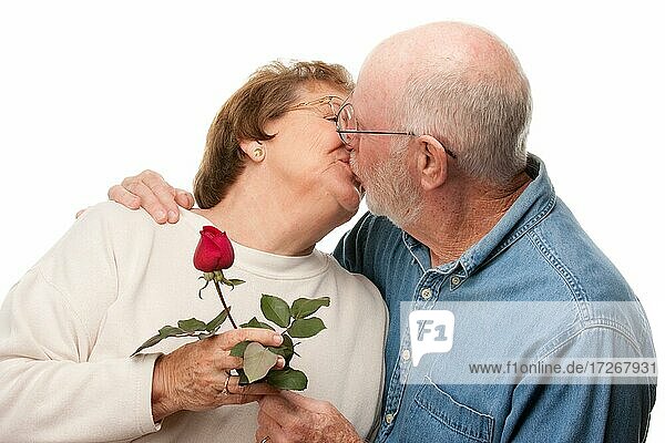 Glückliches älteres Paar mit roter Rose küssen vor einem weißen Hintergrund