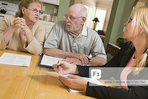 Älteres erwachsenes Paar  das mit einem Agenten die Papiere in seinem Haus durchgeht