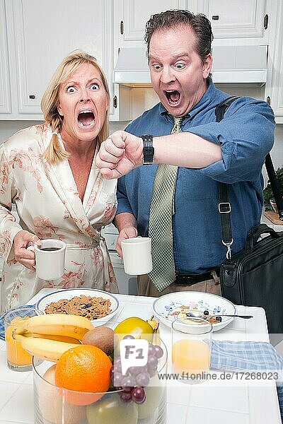 Late for work stressed couple checking time in kitchen
