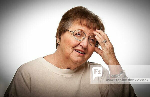 Ältere Frau mit schmerzendem Kopf mit einem dramatischen vignettierten Hintergrund