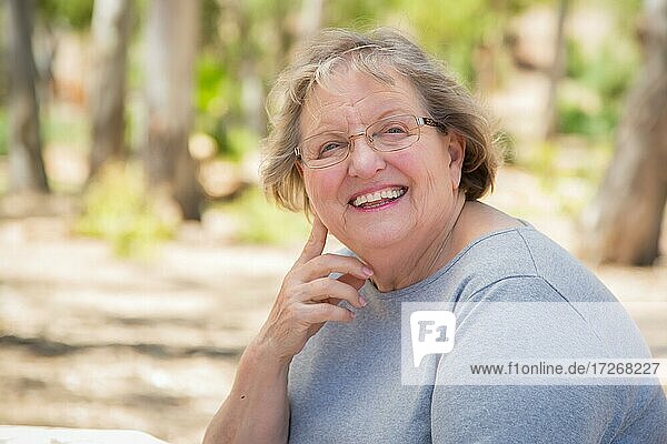 Happy content senior woman portrait outdoors at park