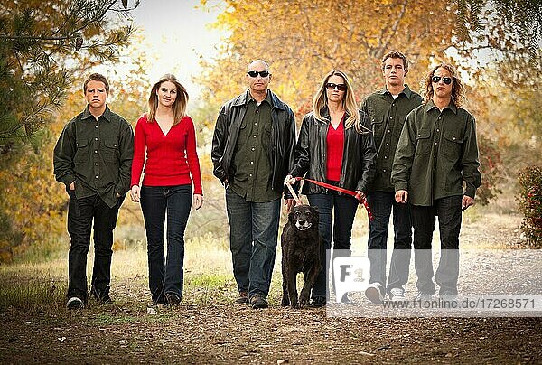 Attractive family portrait walking outdoors with their dog