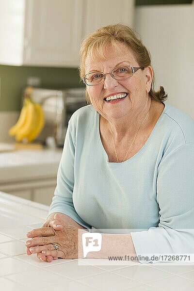 Porträt einer schönen lächelnden älteren erwachsenen Frau in der Küche
