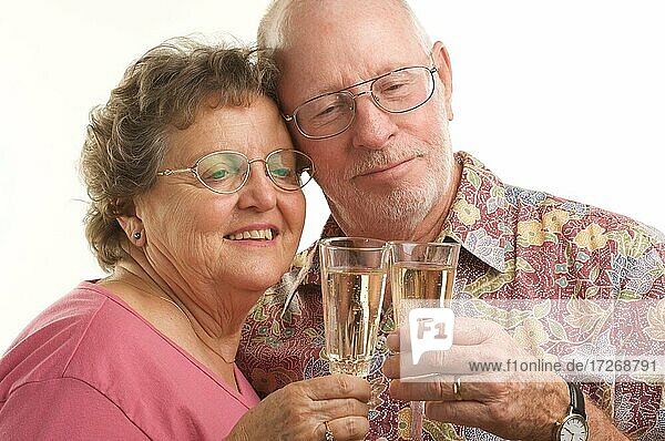 Glückliches Seniorenpaar stößt mit Sektgläsern an