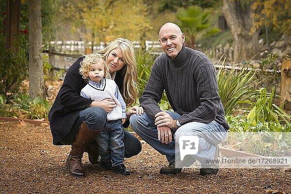 Young attractive parents and child portrait outside in the park