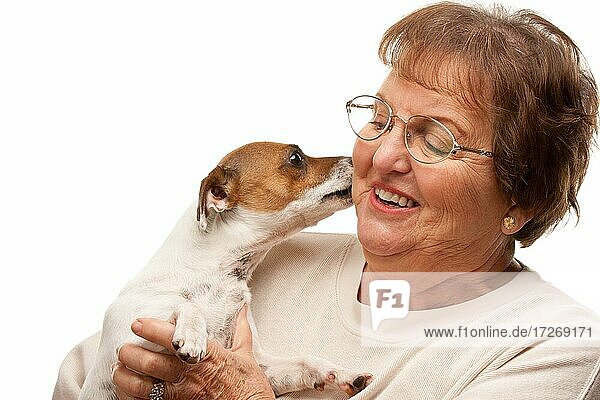 Glückliche attraktive ältere Frau mit Welpe vor einem weißen Hintergrund