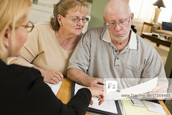 Älteres erwachsenes Paar  das mit einem Agenten die Papiere in seinem Haus durchgeht