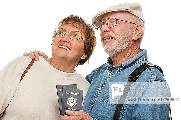Glückliches älteres Paar mit Pässen und Taschen vor einem weißen Hintergrund