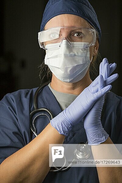 Besorgte Ärztin oder Krankenschwester mit Gesichtsschutz und OP-Handschuhen