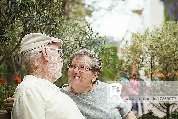 Happy senior couple resting on a bench in the market place