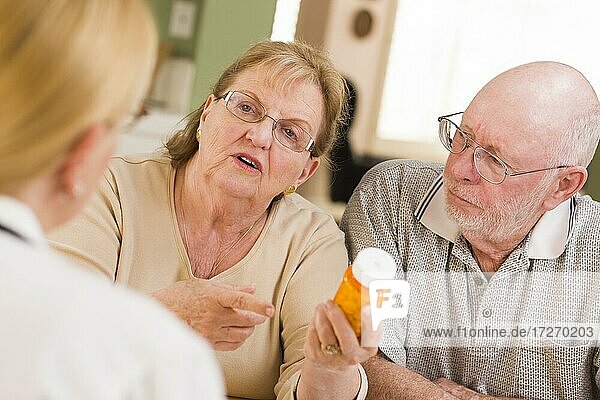 Doctor or nurse explaining prescription medicine to attentive senior couple