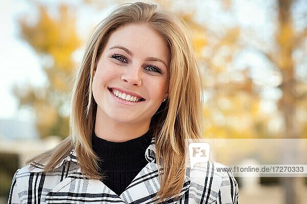 Hübsche junge Frau lächelnd im Park an einem Herbsttag