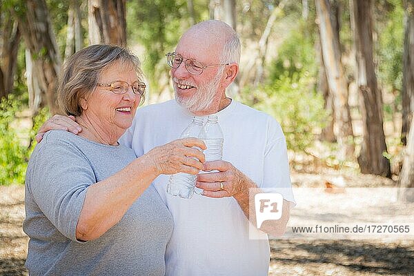 Happy healthy senior couple with water bottles outdoors
