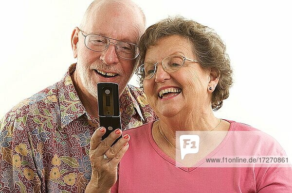 Senior couple looks at the screen of a cell phone