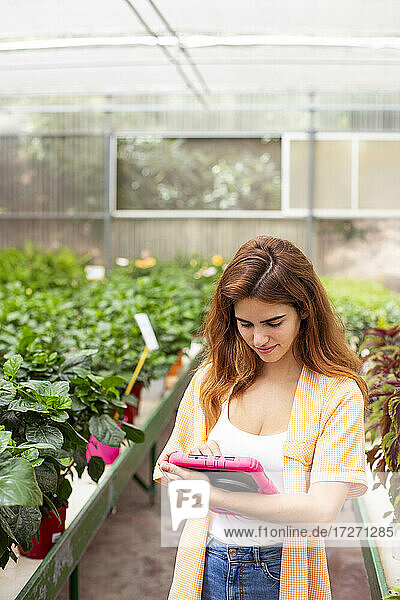 Geschäftsfrau  die ein digitales Tablet benutzt  während sie in einem Gartencenter steht