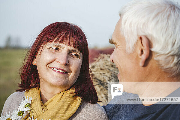Lächelndes älteres Paar  das sich bei der Freizeitgestaltung auf einem Feld ansieht