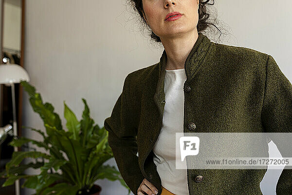 Female model wearing jacket standing against wall