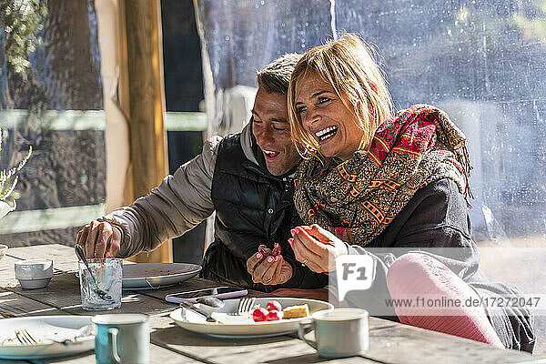 Glückliches reifes Paar genießt das Frühstück am Esstisch in einem Kurort
