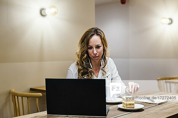 Unternehmerin mit Laptop bei einem Kaffee am Tisch
