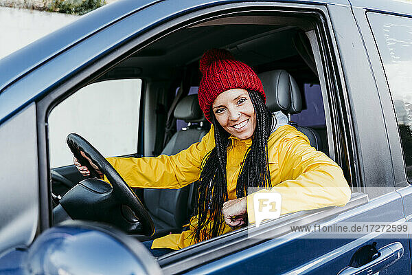 Lächelnde Frau am Steuer eines Autos während eines Ausflugs