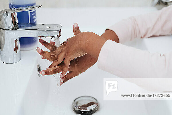 Ausgeschnittenes Bild eines Mädchens beim Händewaschen zu Hause
