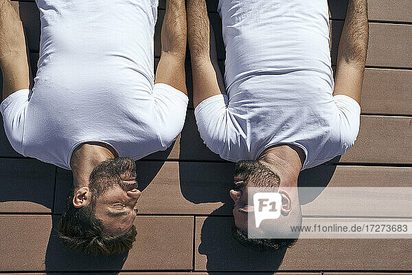 Homosexuelles Paar  das sich an einem sonnigen Tag auf der Diele entspannt