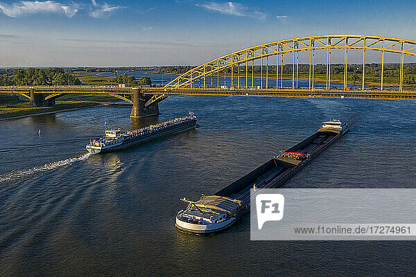 Netherlands  Gelderland  Nijmegen  Aerial view of barge and container ship sailing under bridge on river Waal