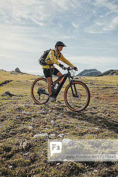 Female mountain biker riding bicycle on mountain at Somiedo Natural Park  Spain